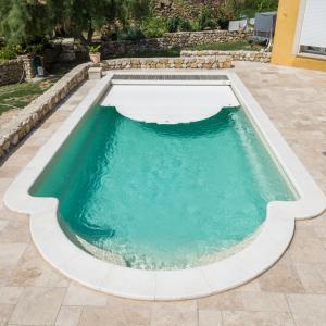 Piscine coque polyester fond plat et escalier roman modèle Maldives